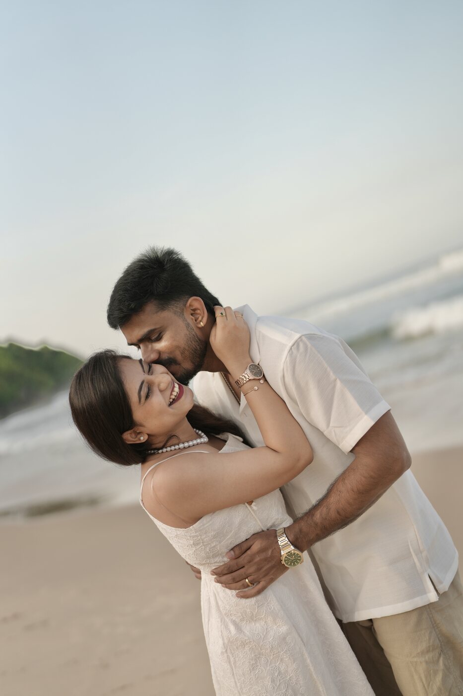 Sanjay dipping Bhoomika on the beach, both laughing
