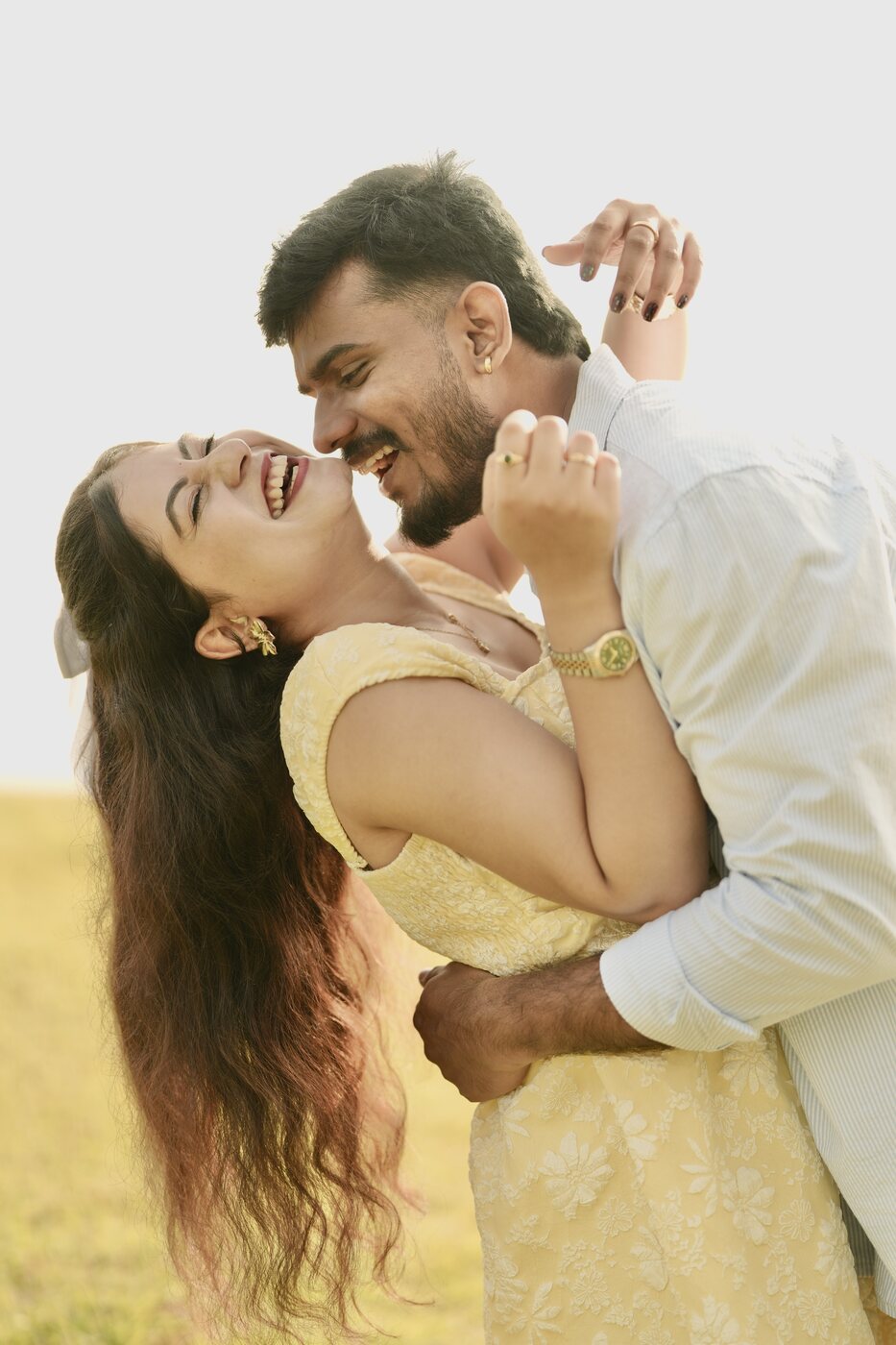 Bhoomika and Sanjay laughing together in a golden field